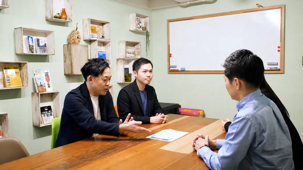 管理組合の相談者へ資料を示しながら説明するコンサルタント