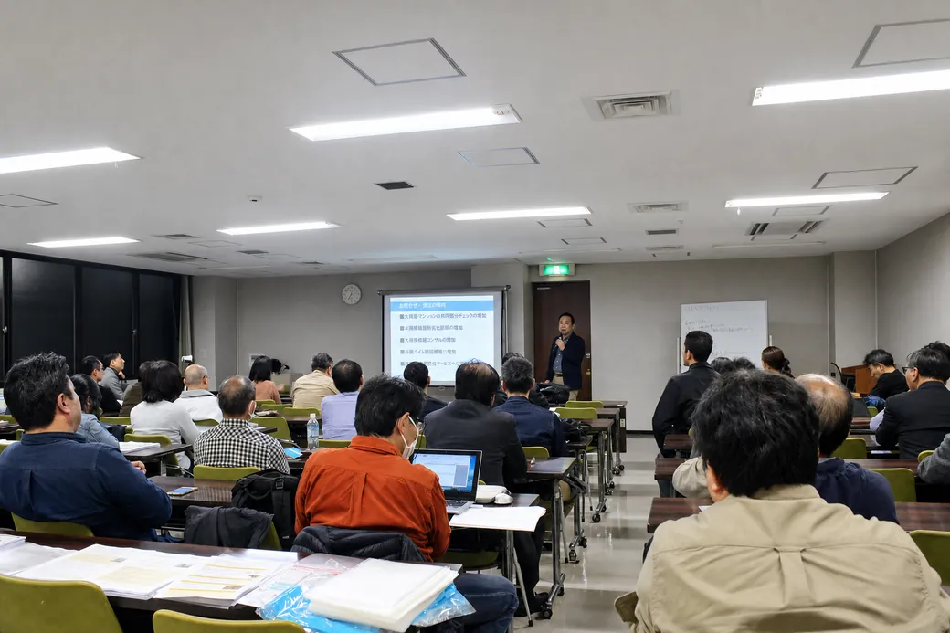 会場で資料を投影しながら参加者へ説明するマンション管理の専門家